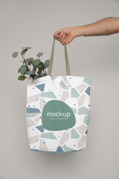 Hand holding tote bag with plant | The Web Univers