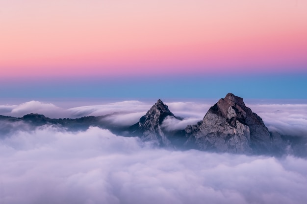 Beautiful aerial shot of fronalpstock mountains in switzerland under the beautiful pink and blue sky | The Web Univers