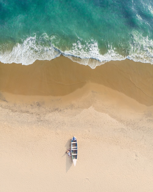Top view shot of people near a boat in the sand of varkala beach | The Web Univers