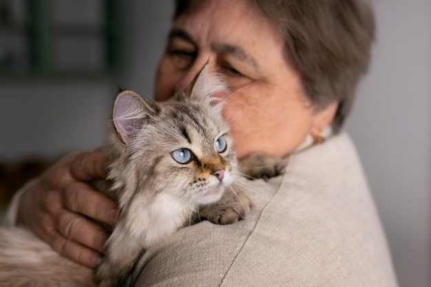 Medium shot elderly woman with cat | The Web Univers