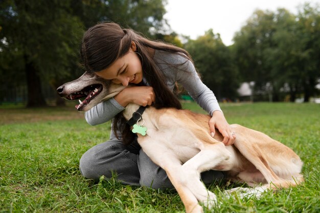 Full shot smiley woman hugging dog | The Web Univers