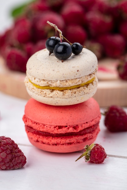 Front view of macarons with raspberries on a white surface | The Web Univers